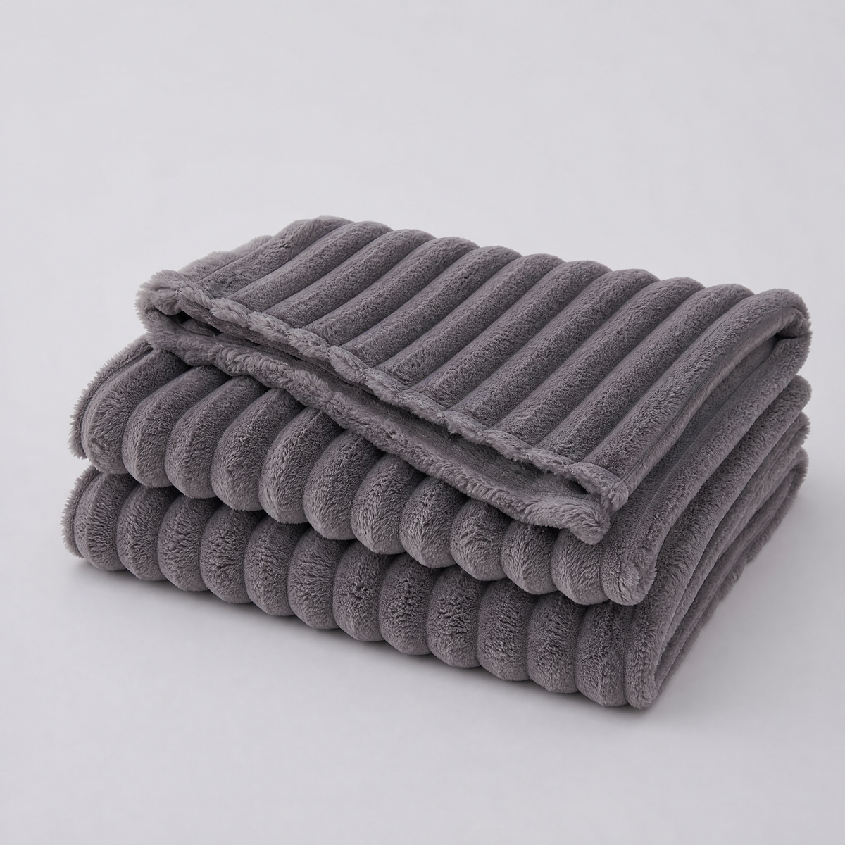 Dark Grey chunky ribbed faux fur couch cover, folded, on a light grey background
