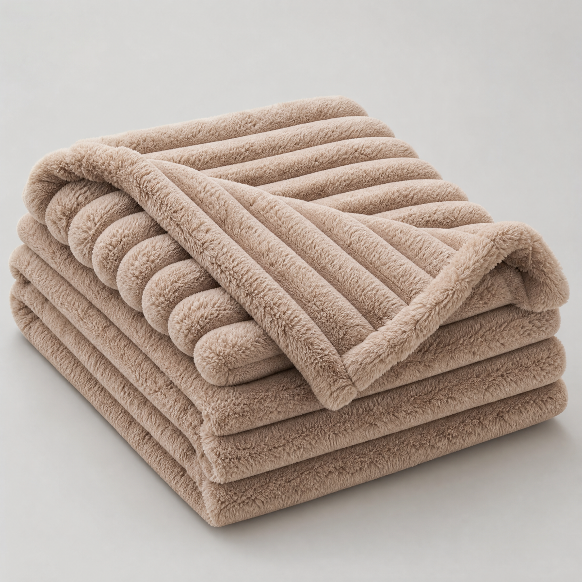 Latte chunky ribbed faux fur couch cover, folded, on a light grey background