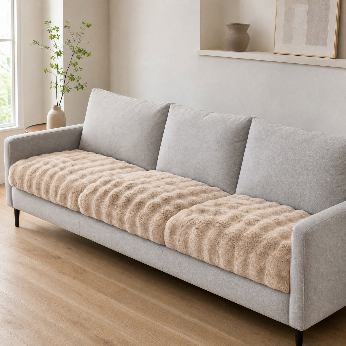 Khaki faux fur cover on the seat of a light grey three seat sofa