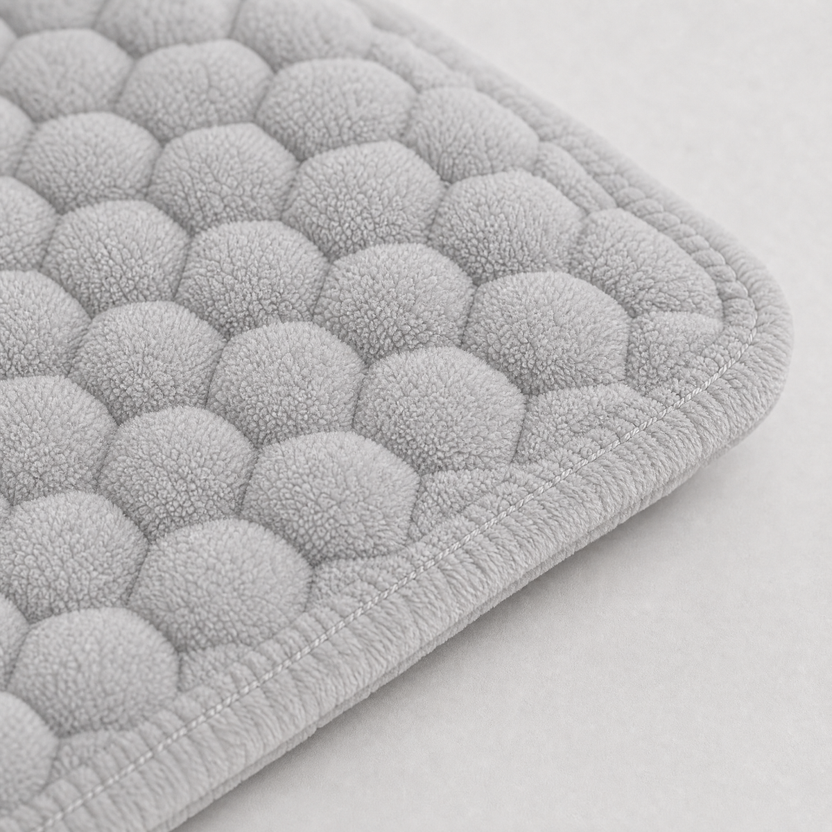 Stitched edge and padded thickness of the grey cover