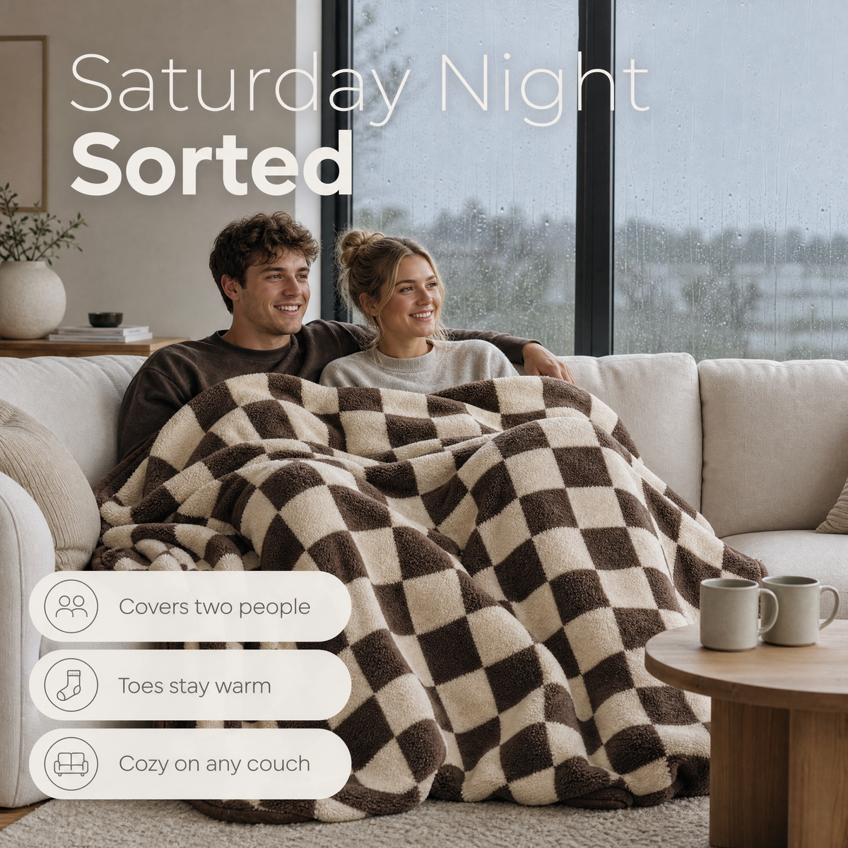 Couple under one checkerboard plush blanket with their feet tucked in