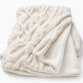 Cream tufted jacquard blanket on a white background