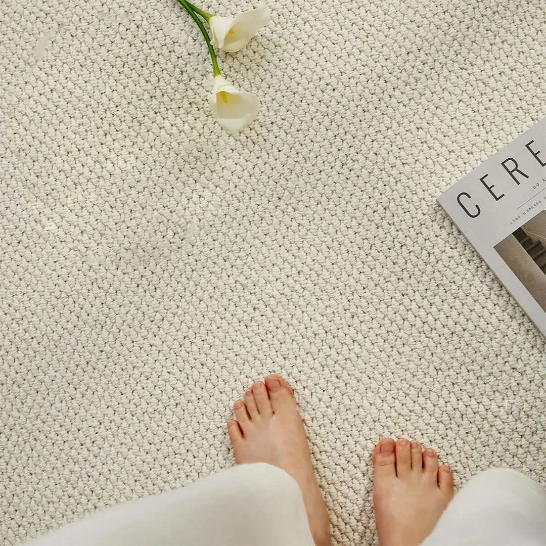 Bare feet on the soft beige door mat