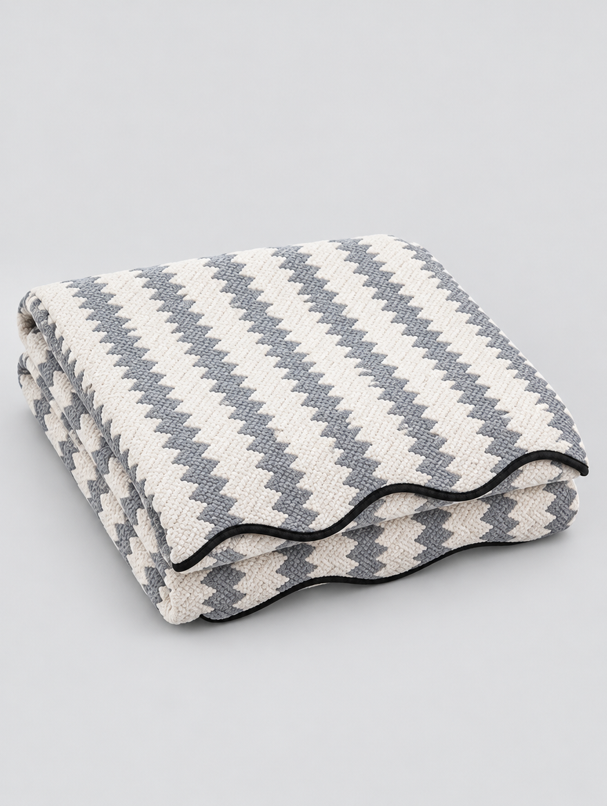 Chevron Chenille Couch Cover in grey, folded on a light grey background