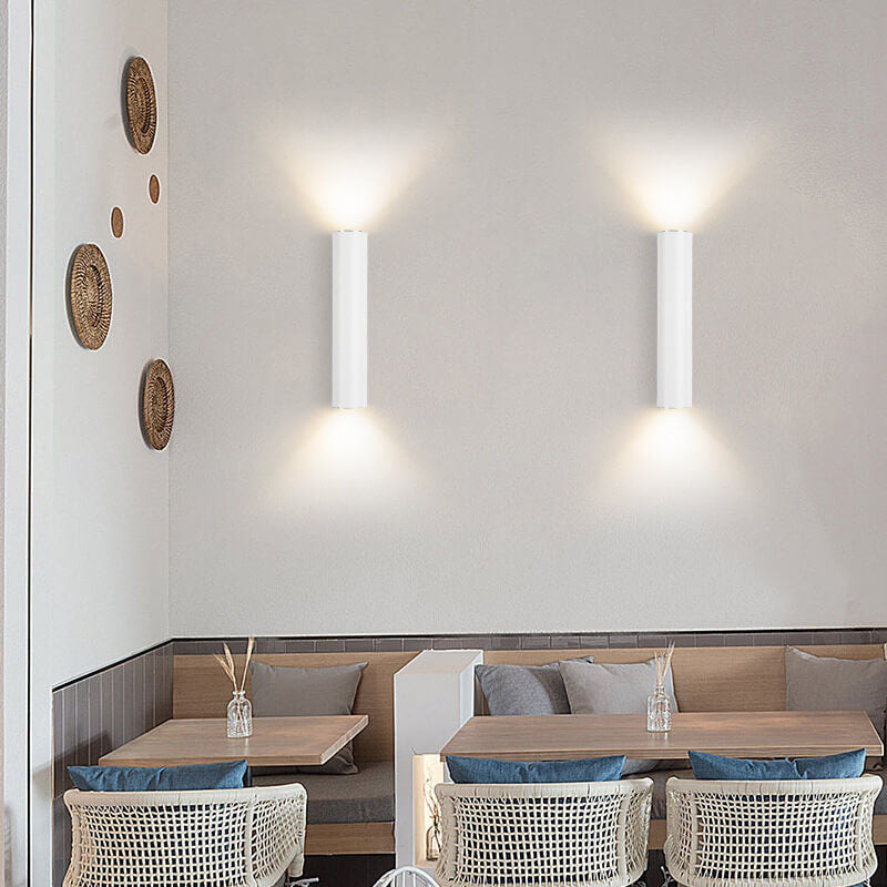 White cylinder wall sconces in a hallway