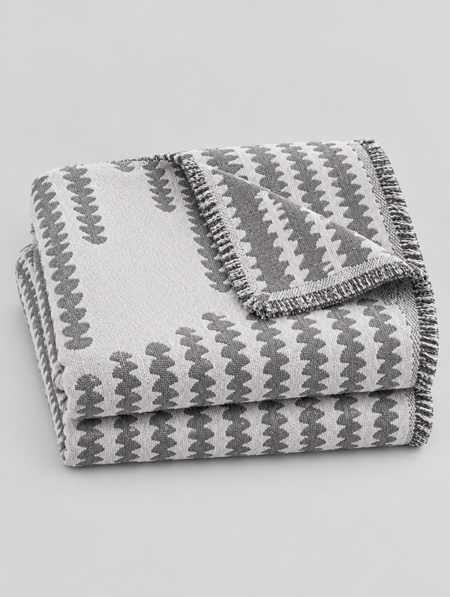 Chenille Couch Cover Throw in grey, folded on a light grey background