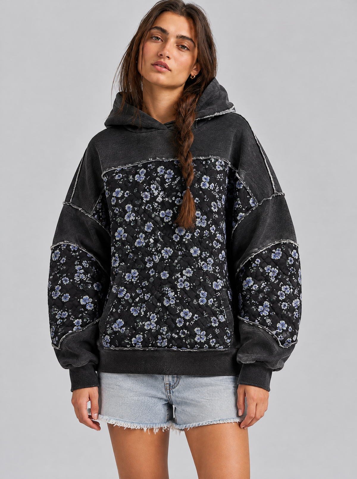 Embroidered panel pullover hoodie in black on a model