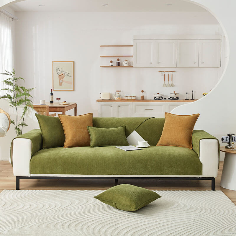 Green herringbone chenille covers on a two seat sofa in a bright living room