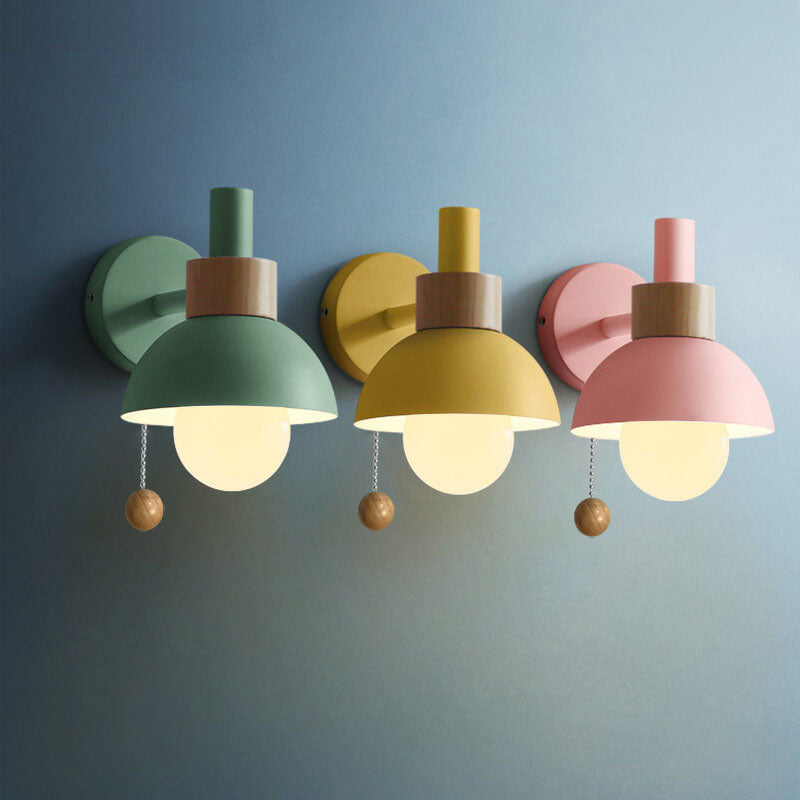 Three pastel globe wall sconces on a blue wall