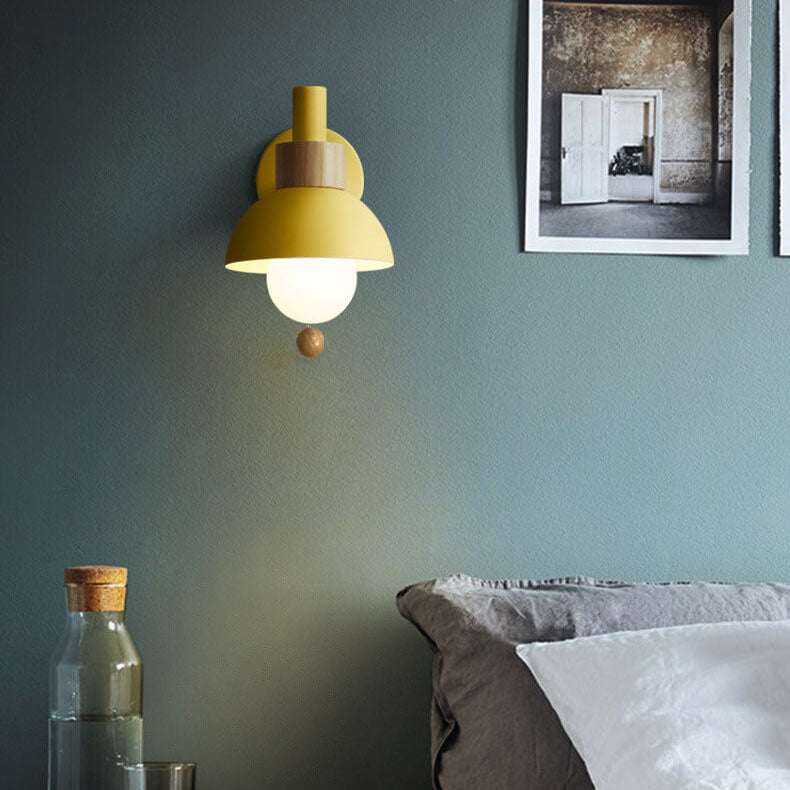 Pink globe wall sconce on a patterned wall