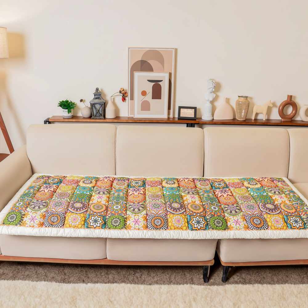 Quilted patchwork couch cover in Bohemia laid over a white sofa