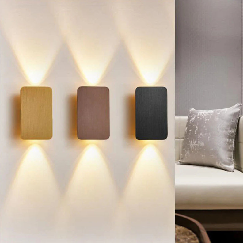 Gold, coffee and black up and down wall sconces on a living room wall