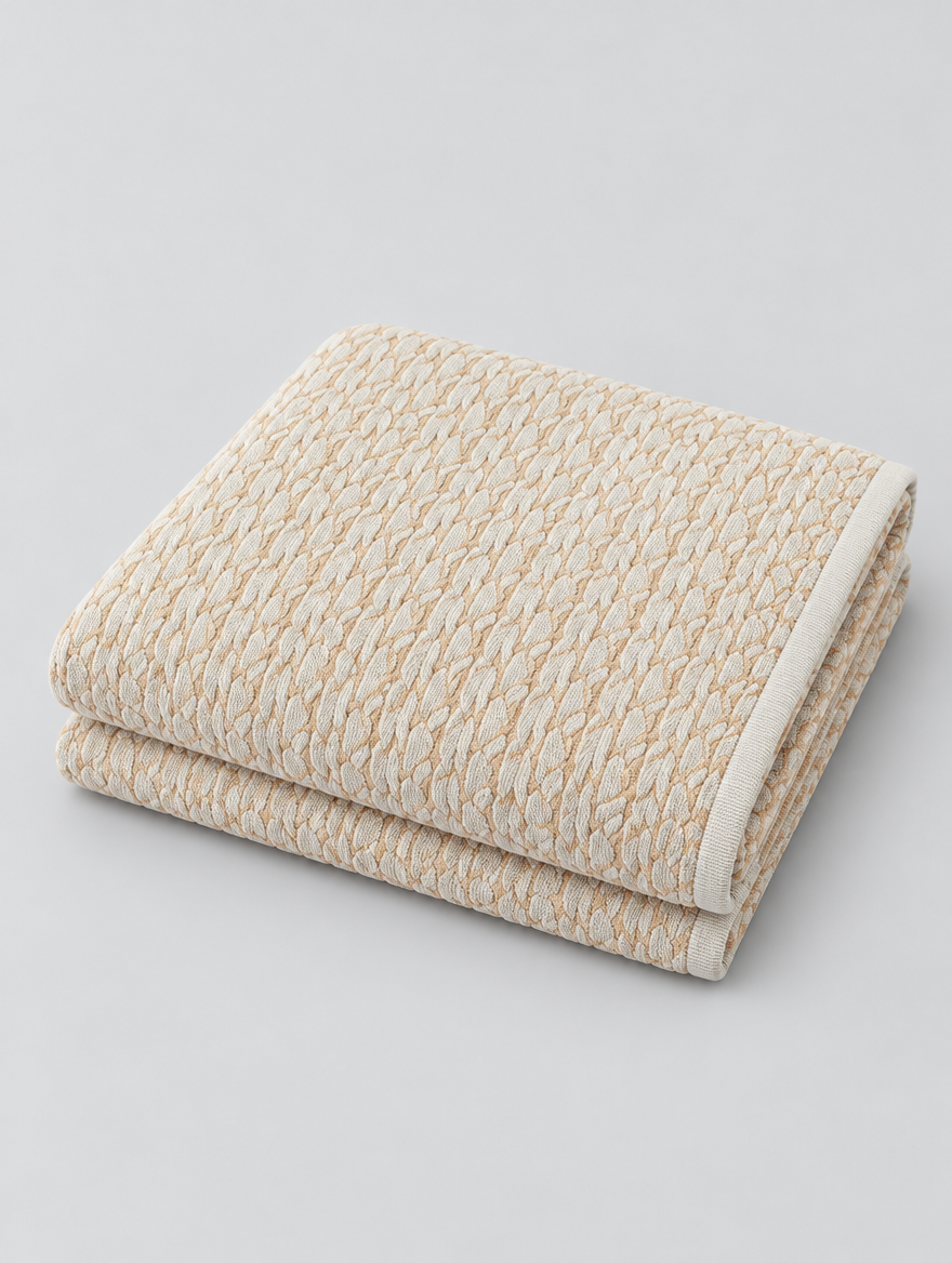 Chenille Couch Cover in beige, folded on a light grey background